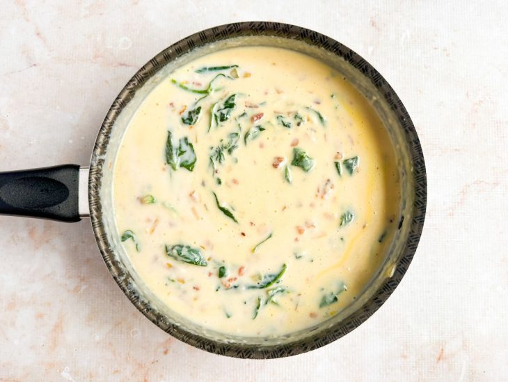 Gemas, bacon, espinafre e mussarela sendo misturados.