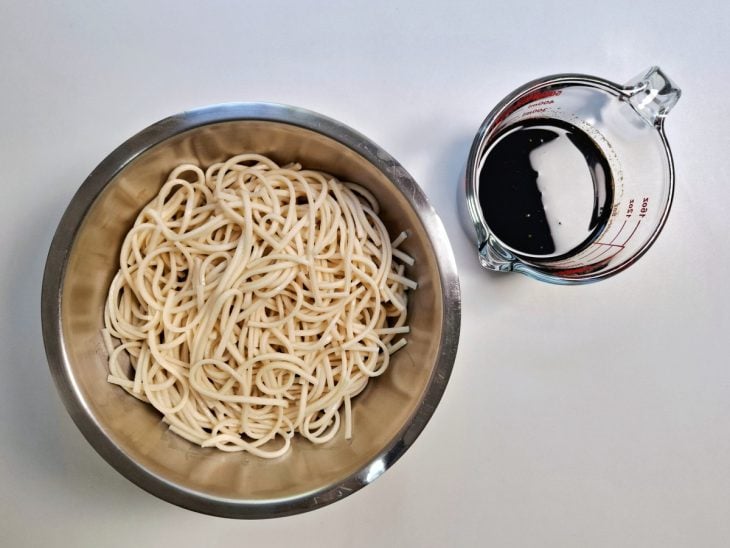 Uma tigela com o macarrão cozido e uma jarra com molho.