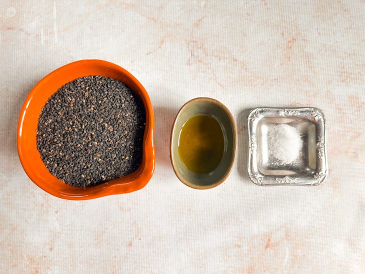 Ingredientes organizados sobre a bancada, com o gergelim preto em destaque.