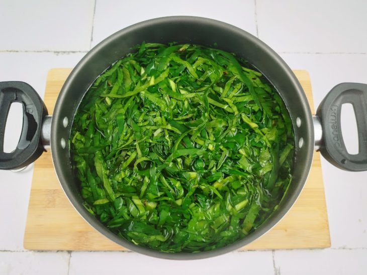 panela com água fervente e tiras de taioba