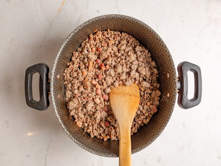 Uma panela com o bacon e carne moída.