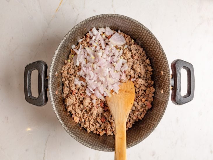 Panela com bacon, carne moída, alho e cenoura.