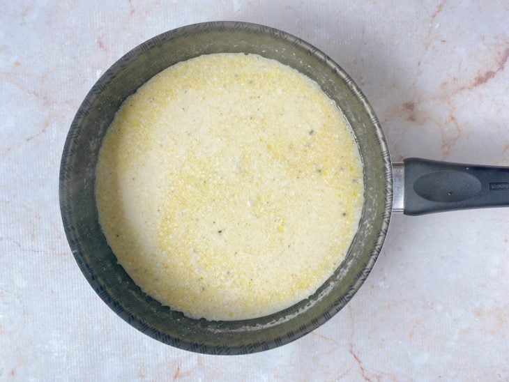 Temperos e queijo adicionados e incorporados na panela.