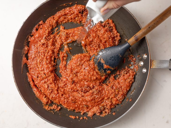 Molho de tomate adicionado na frigideira com carne moída.