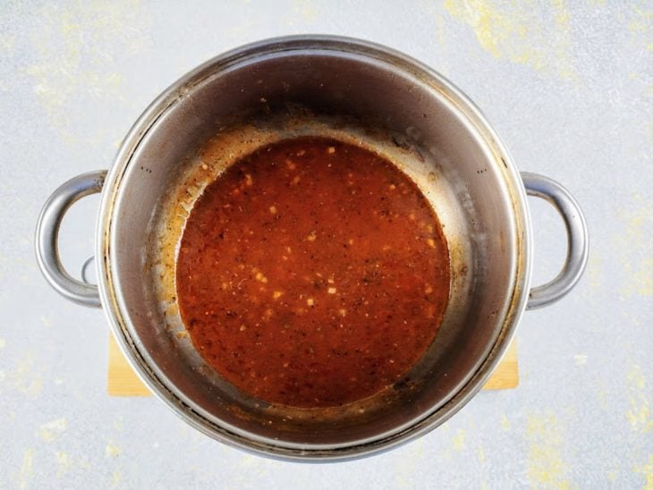 Azeite, alho, molho de tomate e temperos adicionados na panela.