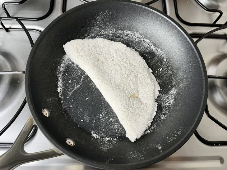 Uma frigideira contendo tapioca com queijo.