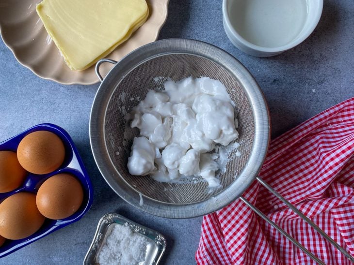 Um recipiente com massa de tapioca na peneira.