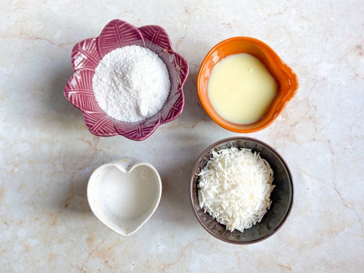 Ingredientes reunidos em recipientes separados sobre uma bancada de mármore.