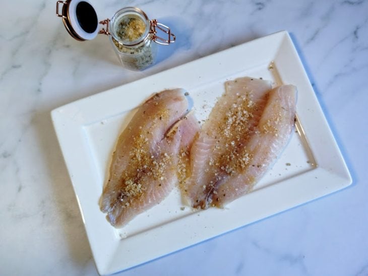 Um prato com peixe e tempero para peixe.