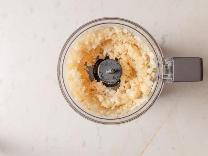 alho triturado em partes em processador de alimentos.