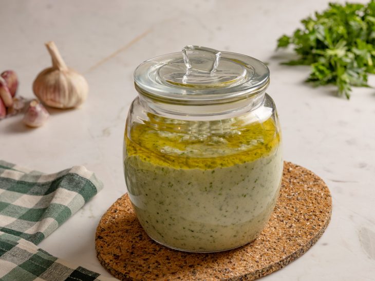 tempero verde armazenado em pote hermético com um fio de azeite.