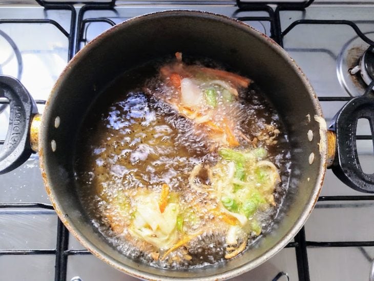 Massa com legumes em óleo fervente.