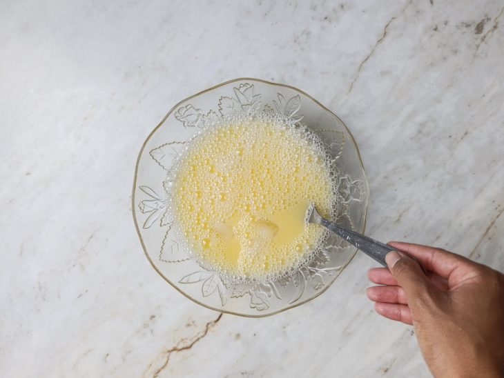 Água gelada com gelo e ovo sendo misturados no bowl.