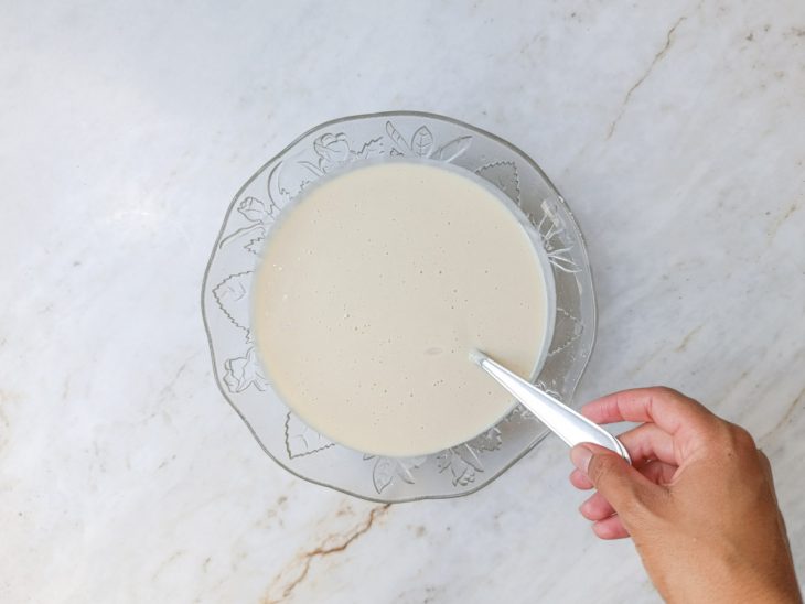 Farinha, amido, fermento e sal peneirados na mistura líquida.