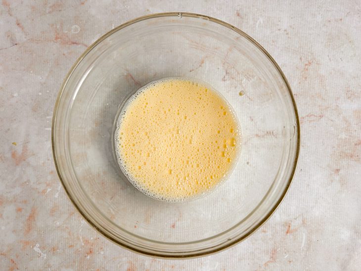 Ovos e leite sendo misturados em uma tigela com fouet.