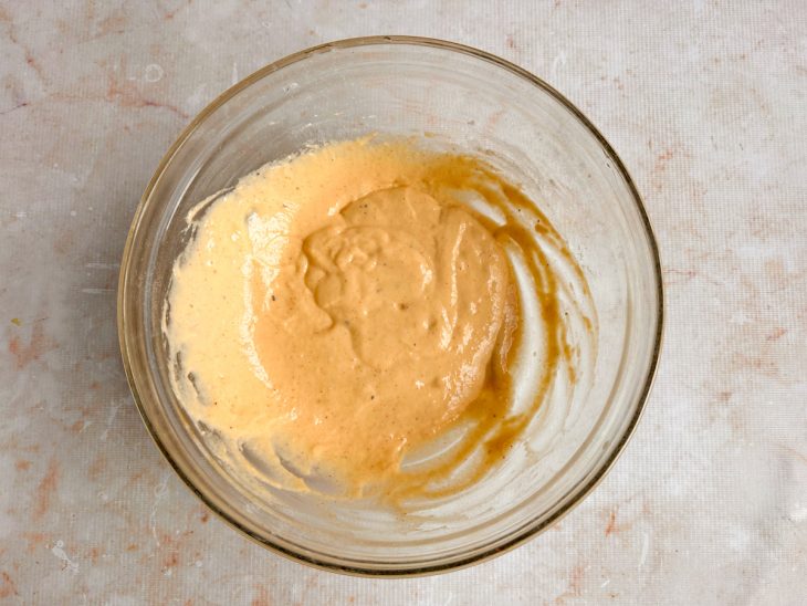 Farinha e temperos sendo incorporados à mistura líquida.