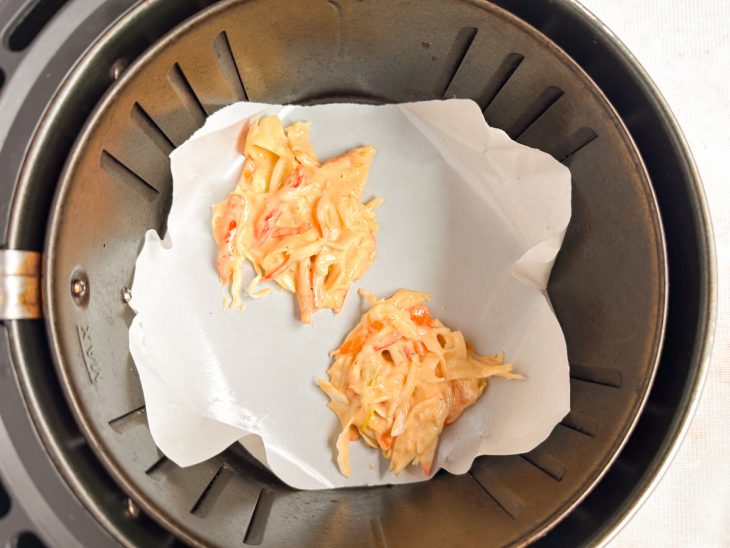 Tempurás sendo dispostos na air fryer antes de assar.