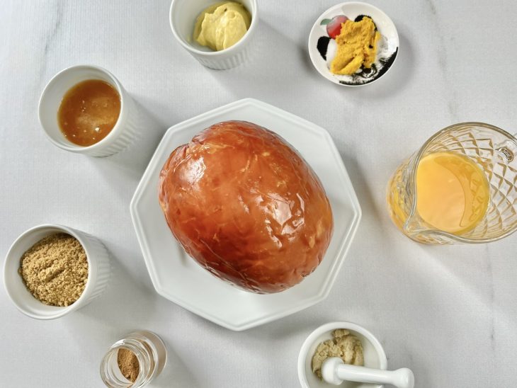 Tender, raspas e suco de laranja, alho e demais ingredientes organizados sobre a bancada.