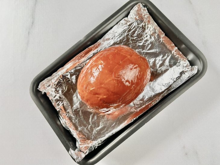 Tender posicionado na forma com cortes cruzados na superfície.