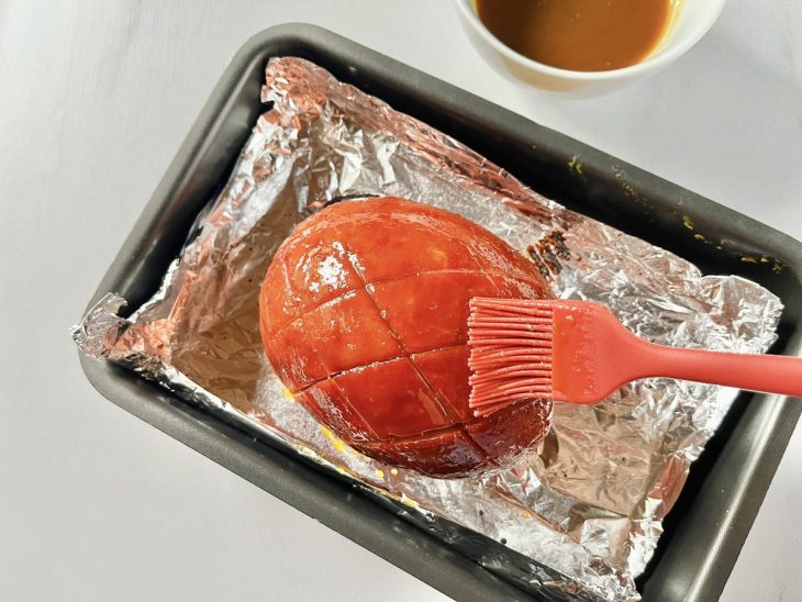 Tender assado recebendo a segunda camada de molho.