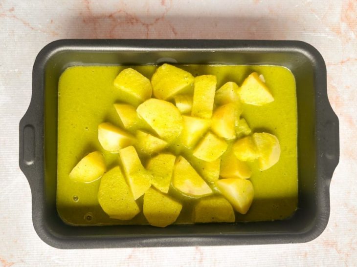 Batatas pré-cozidas dispostas na assadeira.