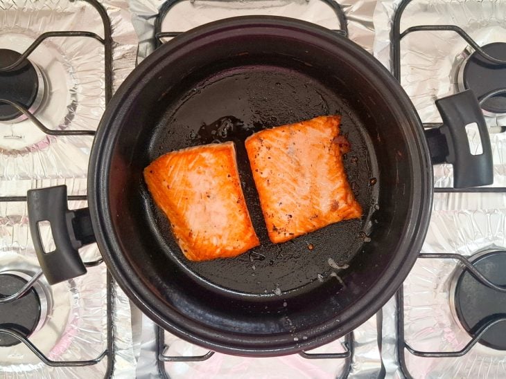 Postas de salmão viradas na panela.