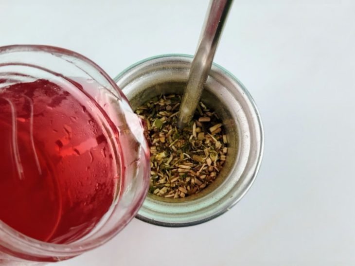 Chá despejado sobre a erva-mate no copo.