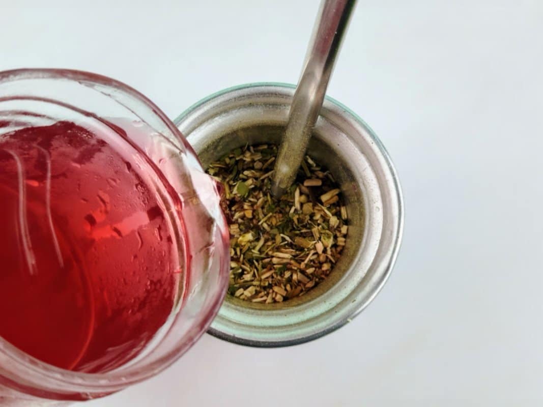 Chá despejado sobre a erva-mate no copo.
