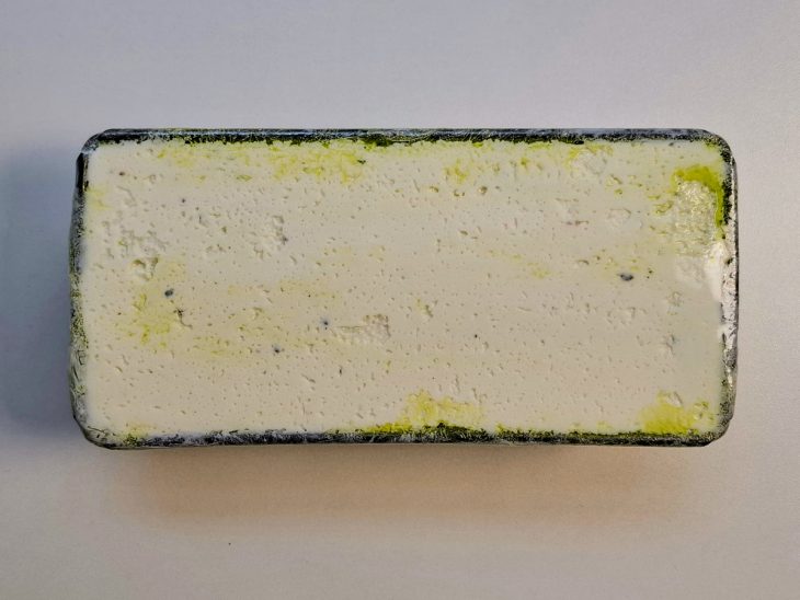 Mistura de queijo e pesto coberta com plástico filme.