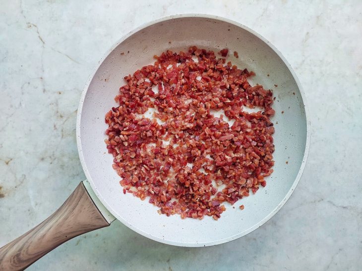 Bacon frito na frigideira.