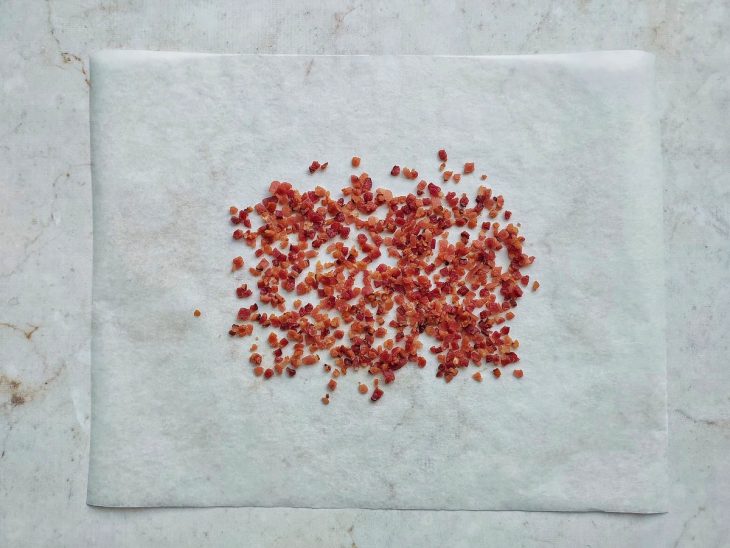 Bacon espalhado sobre um papel manteiga.