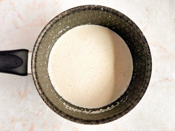 Molho de quatro queijos sendo mexido até ficar cremoso e homogêneo.