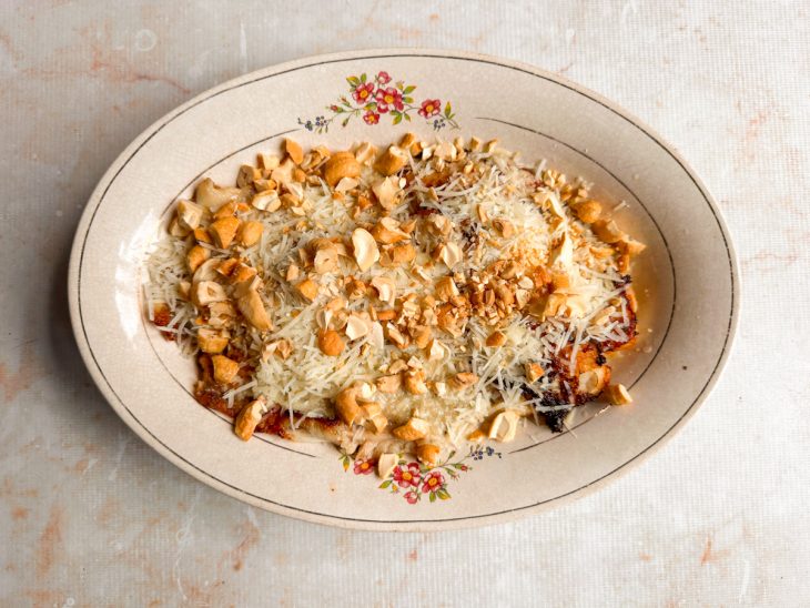 Molho sendo despejado sobre os filés no refratário.