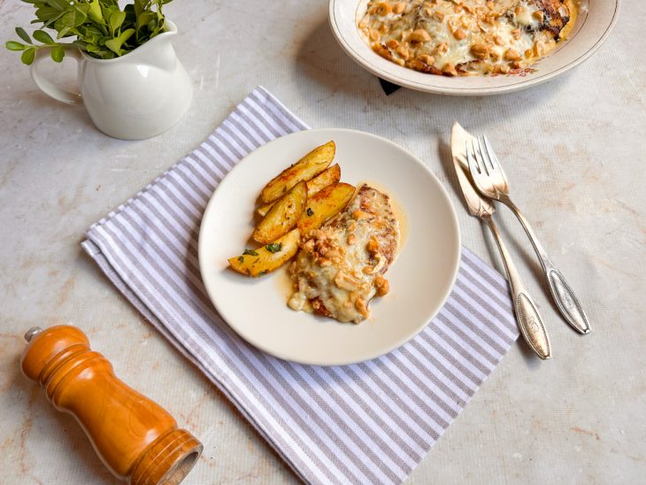 Porção sendo servida com o molho e batatas.