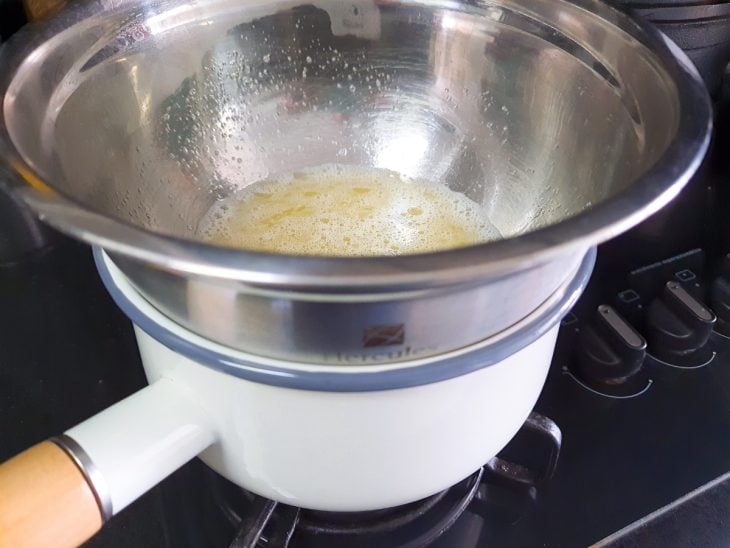 Tigela com claras e açúcar em banho-maria.