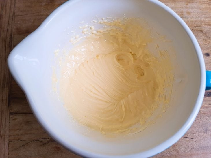 Uma tigela com gemas, açúcar e cream cheese.