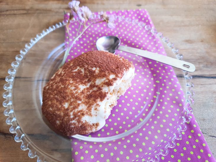 Um prato com um pedaço de tiramisu com cream cheese.