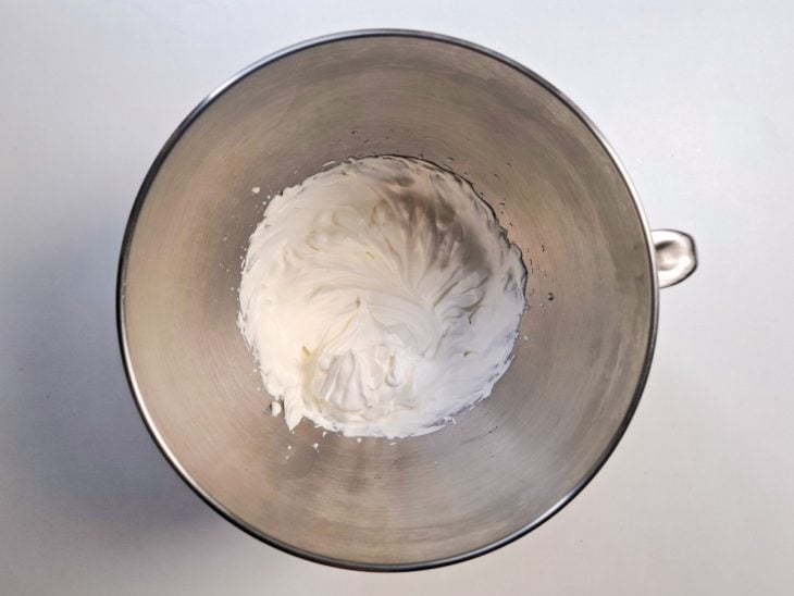 Creme de leite e açúcar batidos em uma tigela de alumínio.