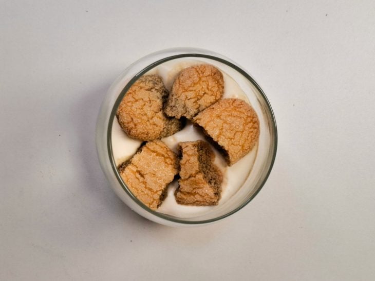 Tiramisù montado em um copo de vidro até a metade.