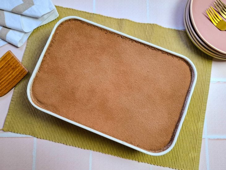 finalização de tiramisu com cacau em pó.
