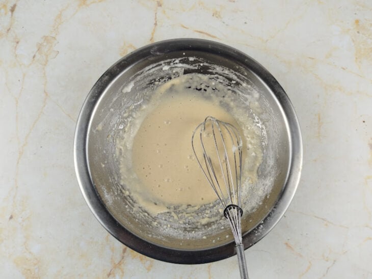 Gema e farinha de arroz sendo misturadas delicadamente às claras batidas.
