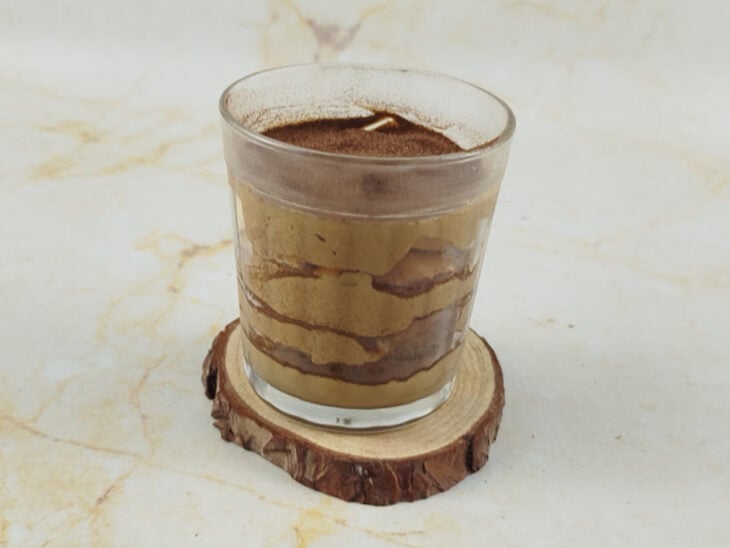 Tiramisù finalizado com creme, cacau peneirado e folha de hortelã.