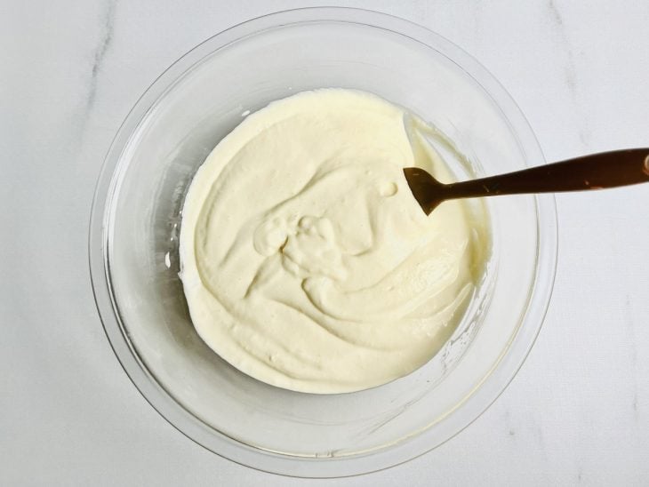 Creme e merengue incorporados na tigela redonda de vidro.