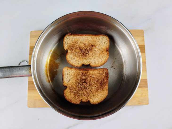 Uma frigideira com os pães a dourar.