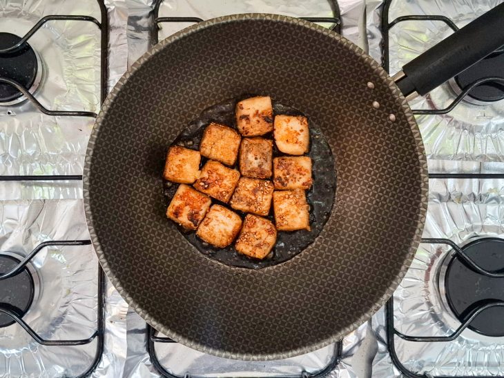 Na frigideira, os tofus são regados com shoyu.