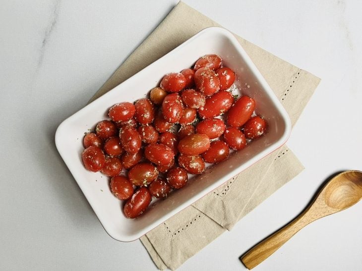Tomates acomodados em um recipiente e temperados.