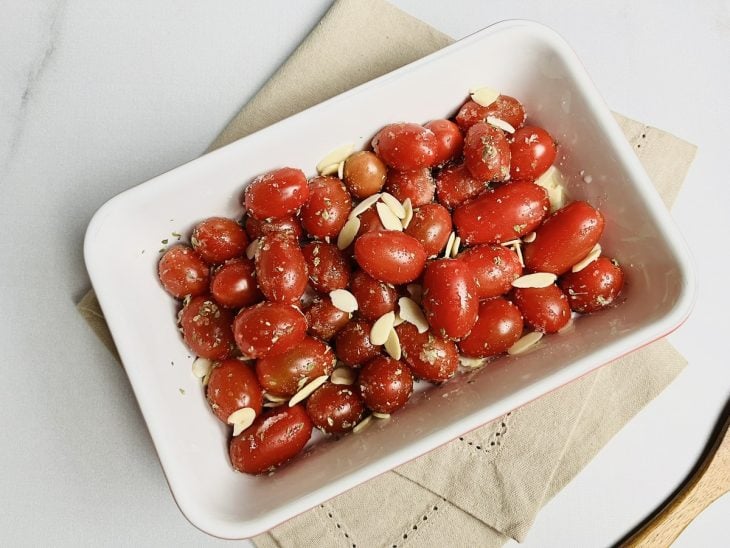 Alho fatiado adicionado entre os tomates.