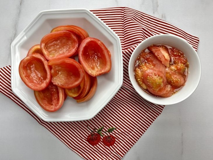 Um recipiente com tomates cortados e outro com a polpa separada.