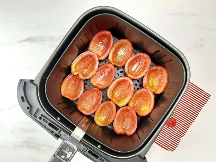 Tomates cortados dispostos em uma airfryer.