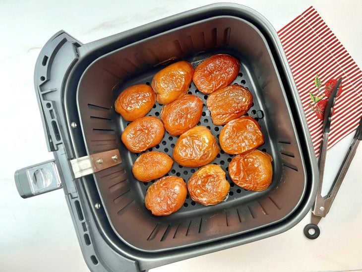 Tomates cortados dispostos em uma airfryer.